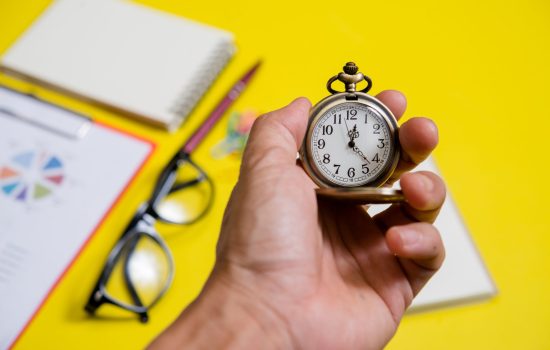 Close up hand holding clock, business concept